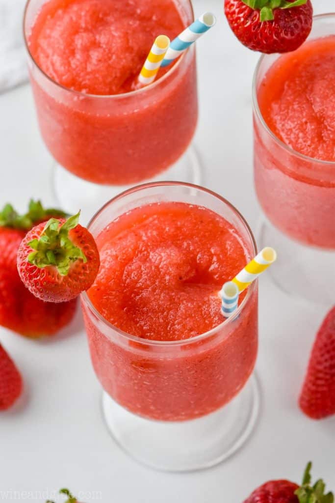 overhead view of three glasses of frozen frose garnished with strawberries
